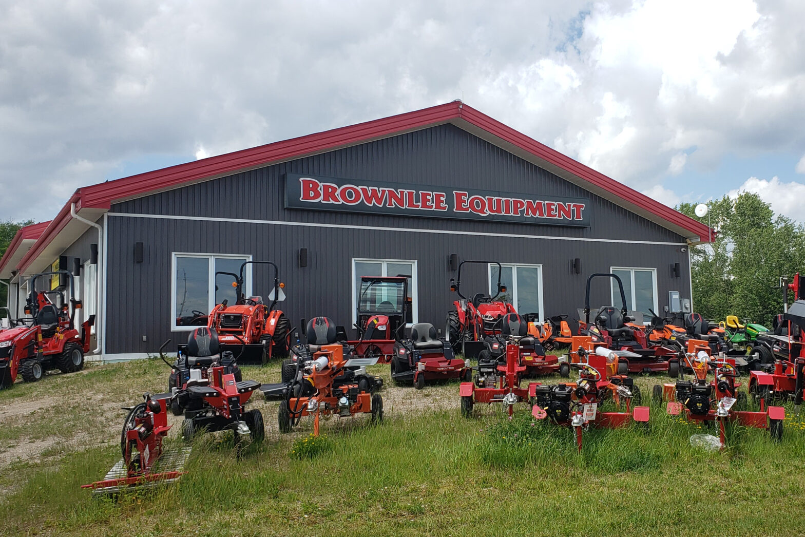 A building reading "Brownlee Equipment" with red tractors parked out front.